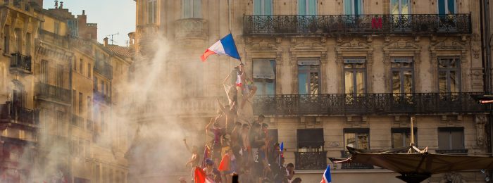 people-climbing-on-fountain-waving-french-flag