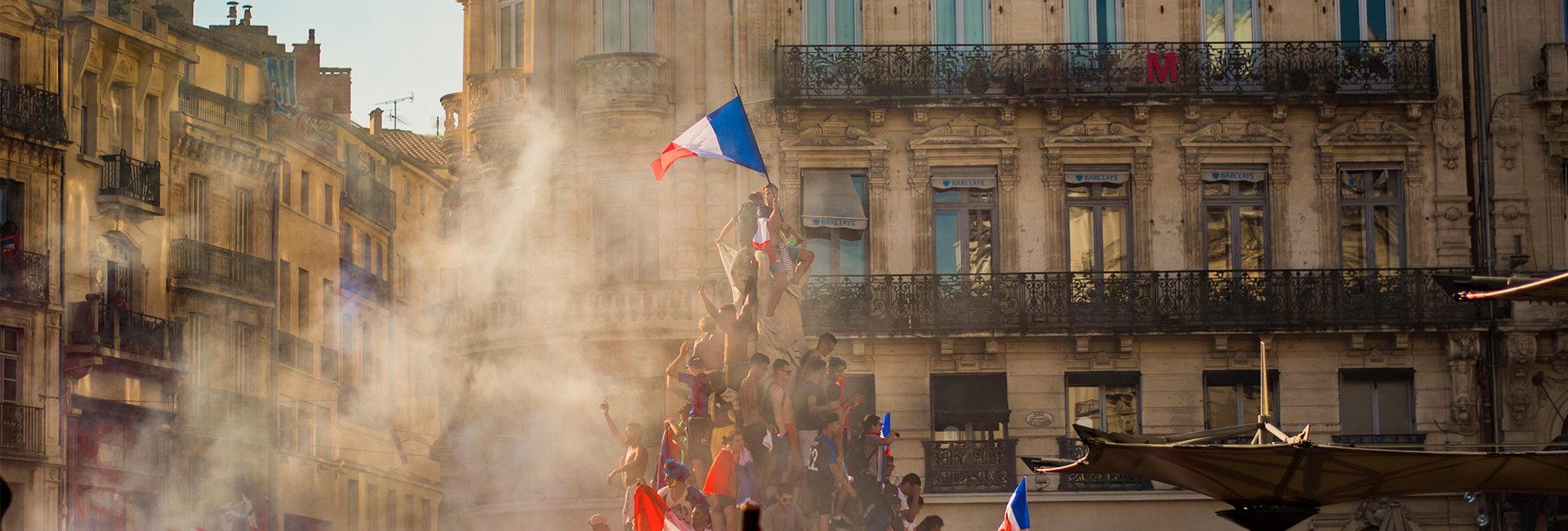 people-climbing-on-fountain-waving-french-flag