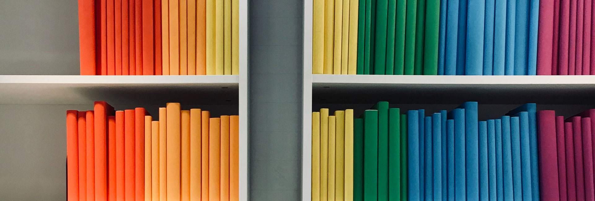 rainbow-colored-books-on-white-shelf
