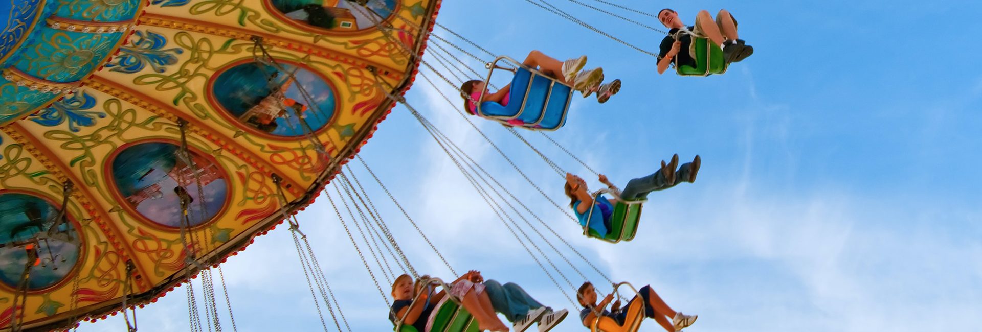 people-on-swing-ride-perspective-from-below-with-blue-sky-above