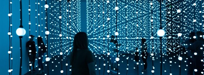 Silhouette of woman standing in front of blue lights photo