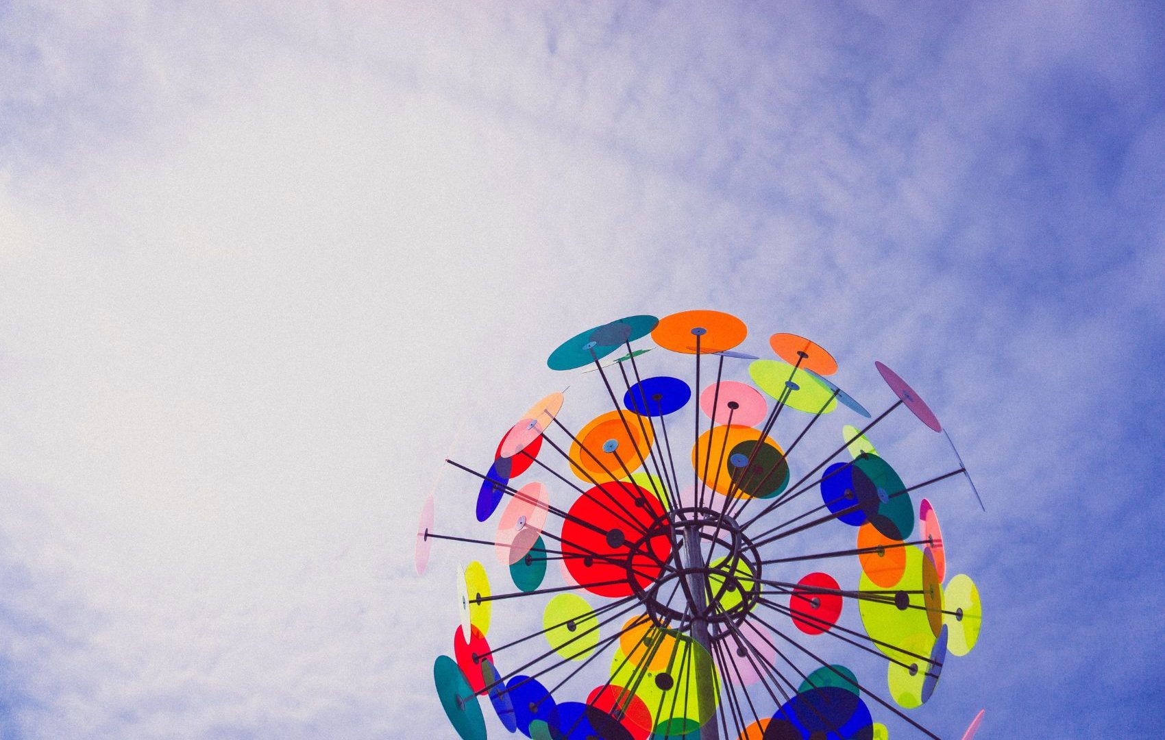 colorful-disc-sculpture-in-blue-cloudy-sky-photo