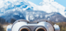 touristic telescope look at the city with view snow mountains