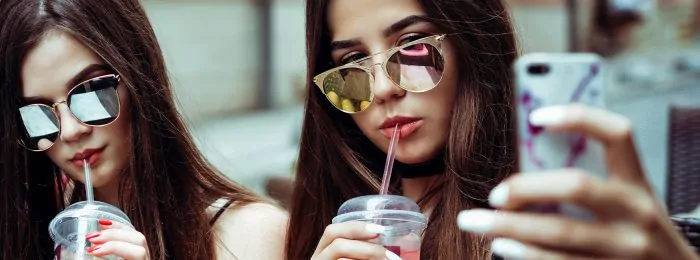 two-people-drinking-wearing-sunglasses-taking-selfie