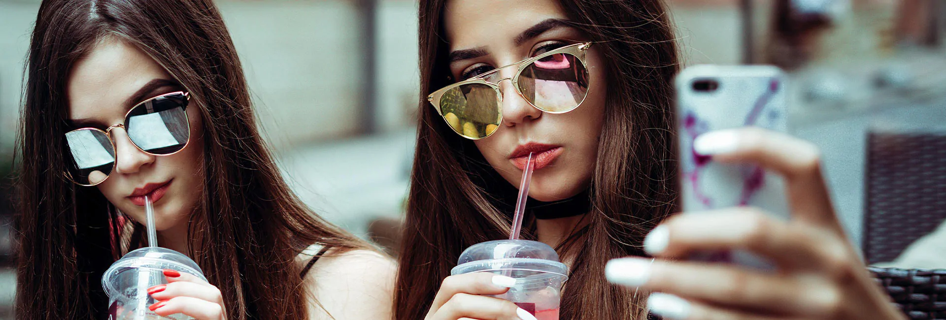 two-people-drinking-wearing-sunglasses-taking-selfie