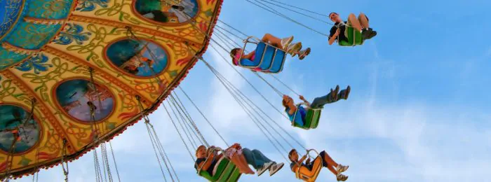 people-on-swing-ride-perspective-from-below-with-blue-sky-above