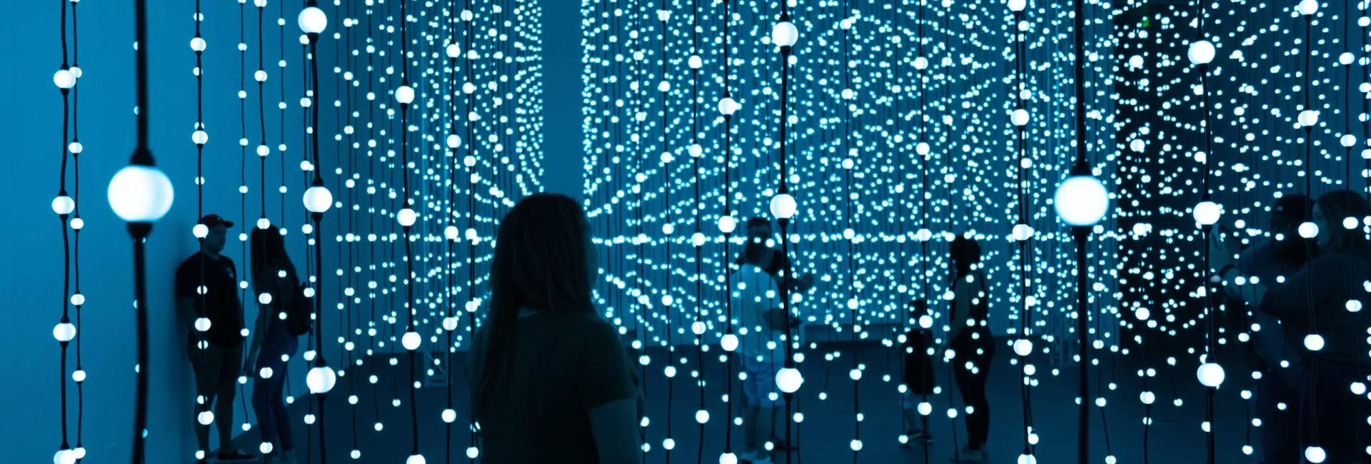 Silhouette of woman standing in front of blue lights photo