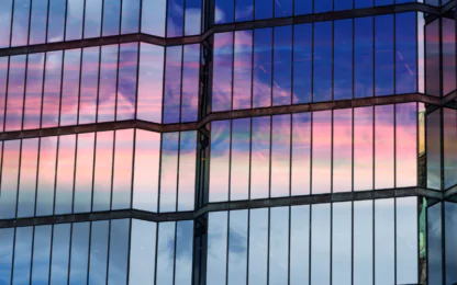Clouds at sunset are reflected in the windows of the skyscraper. Glass facade of a modern office building