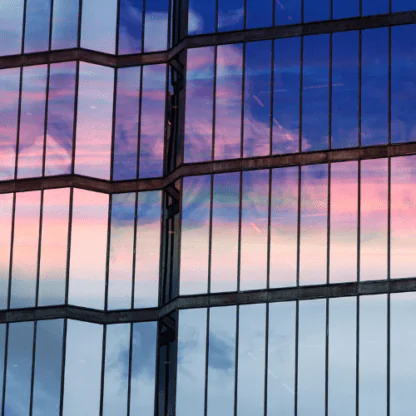 Clouds at sunset are reflected in the windows of the skyscraper. Glass facade of a modern office building