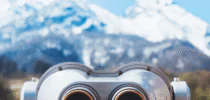 touristic telescope look at the city with view snow mountains