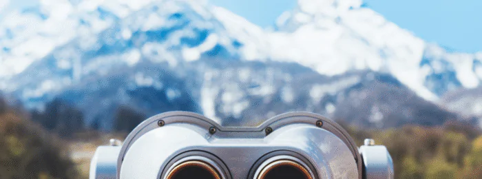 touristic telescope look at the city with view snow mountains